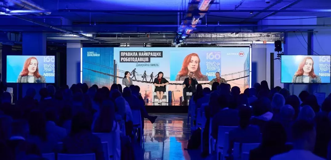 Панельна дискусія про правила на робочому місці під час бізнес-конференції, вид з аудиторії при синьому освітленні.